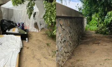 Two images side by side the left image is of an homeless encampment next to a retaining wall, the second image on the right side is after a cleanup was performed and you can see all the litter and debris have been removed