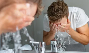 Man washing face in sink