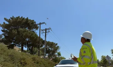 Inspector flying drone over electrical poles
