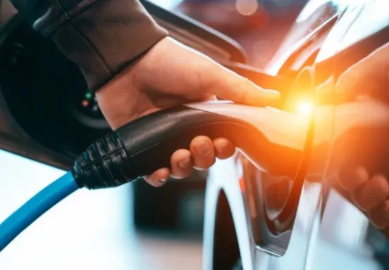 Image of a charger being plugged into an electric vehicle