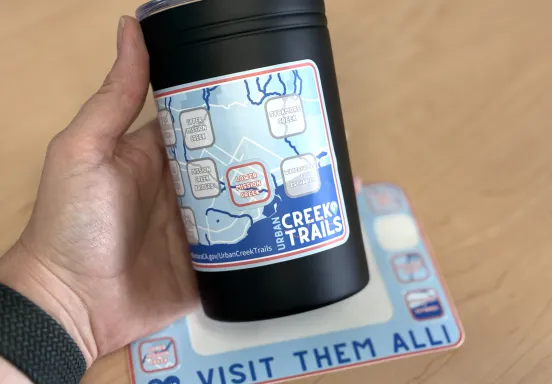 Urban Creek Trails sticker on a travel mug