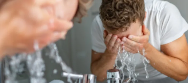 Man washing face in sink