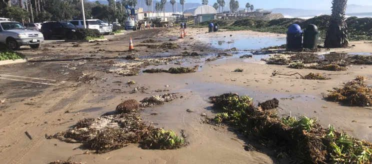 Parking lot at Leadbetter Beach and the Harbor covered in sand and debris in February 2024