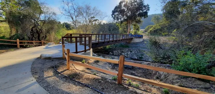 Footbridge at Arroyo Burro Open Space with sun behind trees.