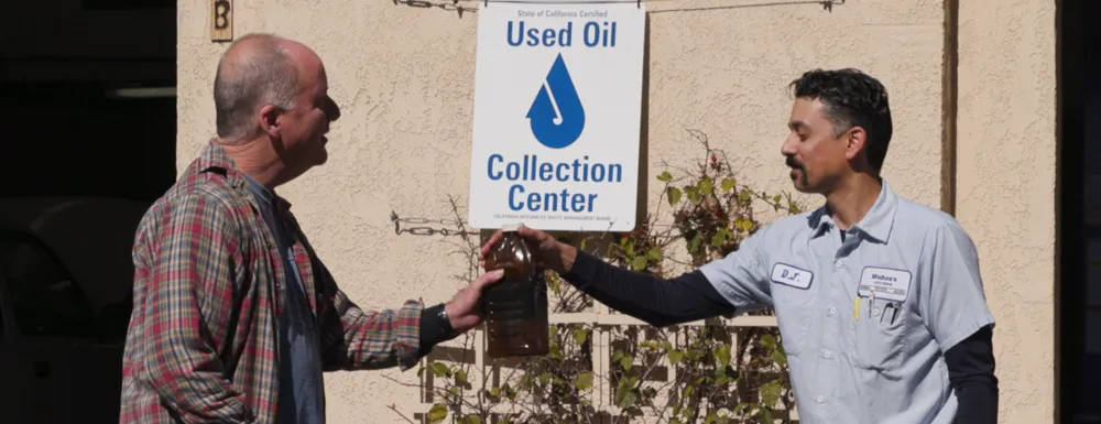 A community member returns motor oil to a Used Oil Collection Center