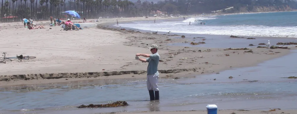 City staff collecting beach water quality sample