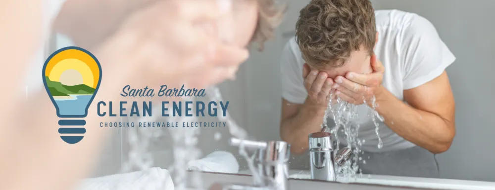 Man washing his face in bathroom sink with a reflection in the mirror, and the Santa Barbara Clean Energy logo