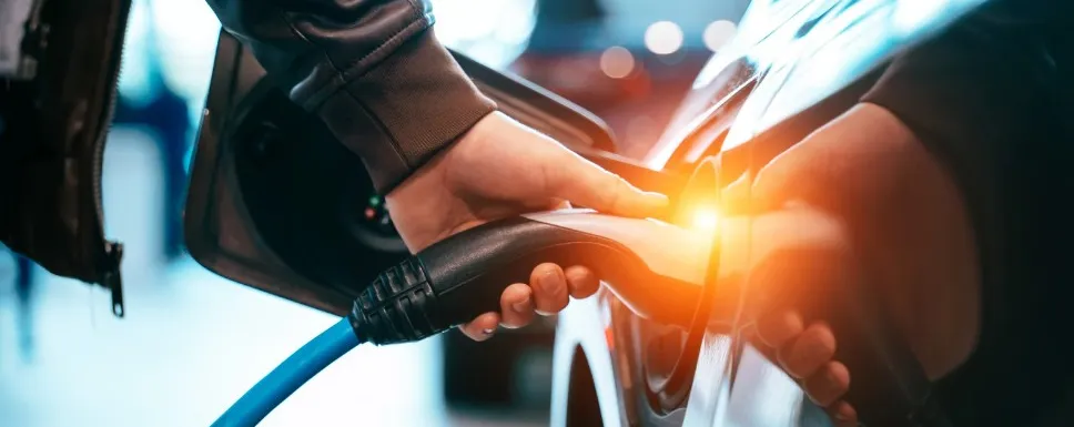 Image of a charger being plugged into an electric vehicle