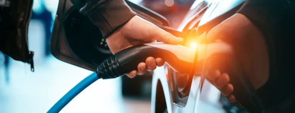 Image of a charger being plugged into an electric vehicle