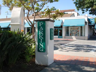 Entrance sign at Parking Lot 12 in Downtown Santa Barbara with businesses in the background